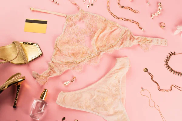 Vista dall'alto lingerie, carta di credito e accessori su sfondo rosa — Foto stock