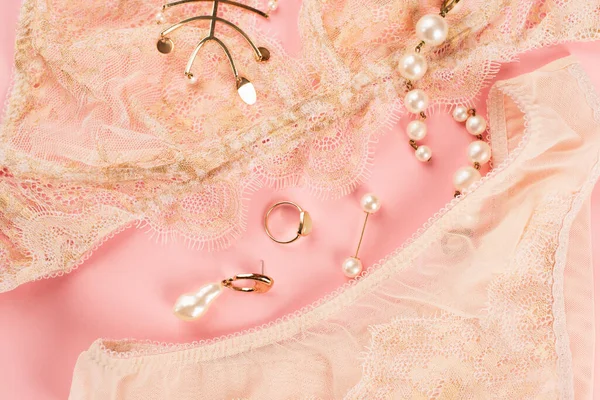 Top view of accessories near lace lingerie on pink background — Stock Photo