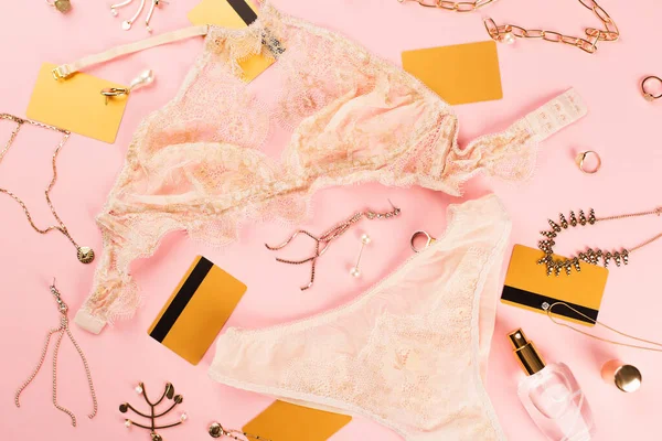 Vista dall'alto di carte di credito, accessori e lingerie su sfondo rosa — Foto stock