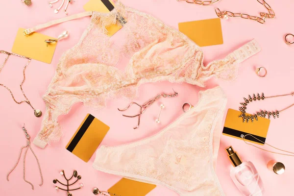 Vista superior de cartões de crédito, acessórios e lingerie sobre fundo rosa — Fotografia de Stock