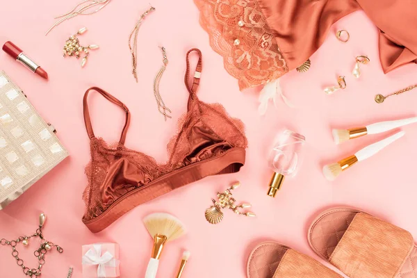 Vue du dessus du soutien-gorge, cadeau près du parfum et des pantoufles sur fond rose — Photo de stock