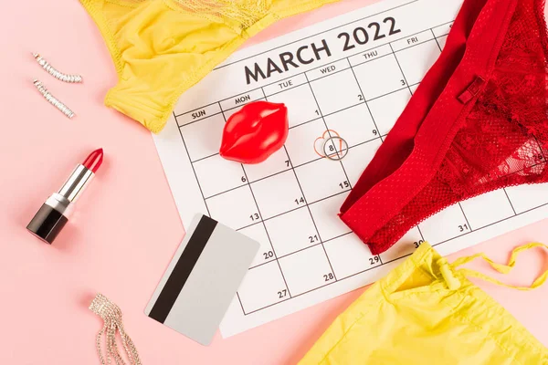 Draufsicht auf März-Kalender, Dessous und Kreditkarte auf rosa Hintergrund — Stockfoto