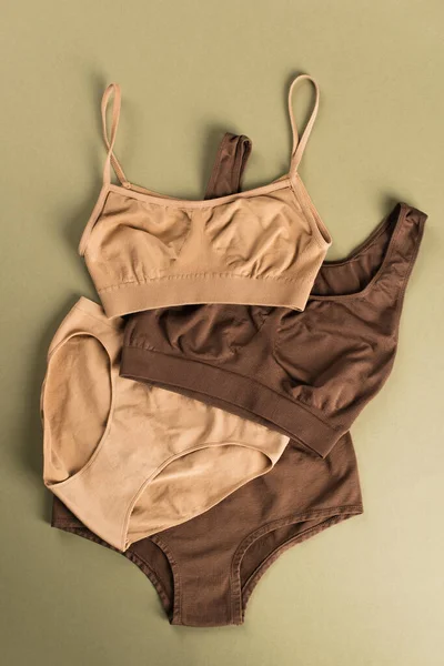 Top view of beige and brown cotton underwear on green background — Stock Photo