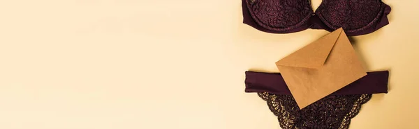 Vista dall'alto di lingerie di pizzo e busta su sfondo beige, banner — Foto stock