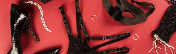 Visão superior da máscara sexual, calcinha e saltos no fundo vermelho, banner — Fotografia de Stock