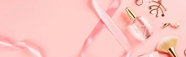 Top view of ribbon in shape of 8 sign near perfume and accessories on pink background, banner — Stock Photo