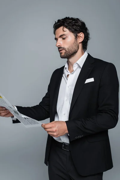 Homme d'affaires en blazer noir et chemise blanche lecture journal isolé sur gris — Photo de stock