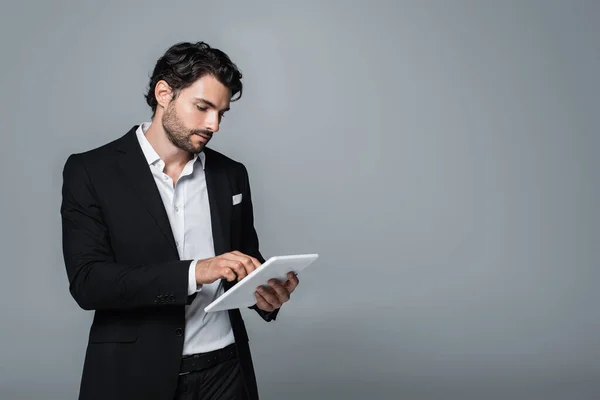 Uomo d'affari in blazer nero e camicia bianca con tablet digitale isolato su grigio — Foto stock