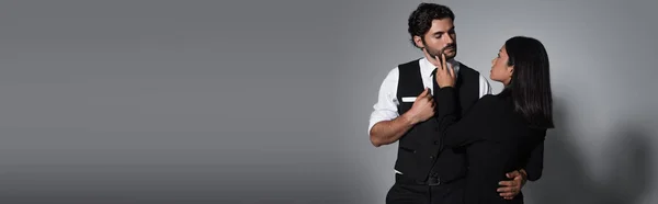 Rückseite einer asiatischen Frau, die das Gesicht eines eleganten Mannes auf grauem Hintergrund berührt, Banner — Stockfoto