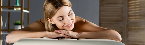 Gioiosa giovane donna sdraiata sul tavolo da massaggio, striscione — Foto stock
