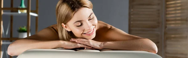 Alegre joven mujer acostada en la mesa de masaje, pancarta - foto de stock