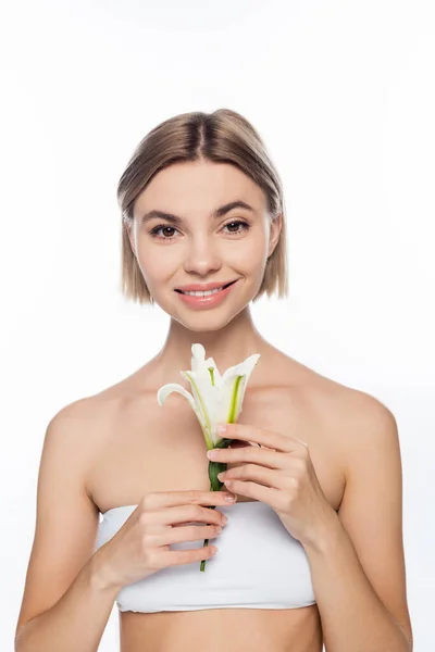 Щаслива жінка з голими плечима тримає квітучу квітку ізольовано на білому — стокове фото