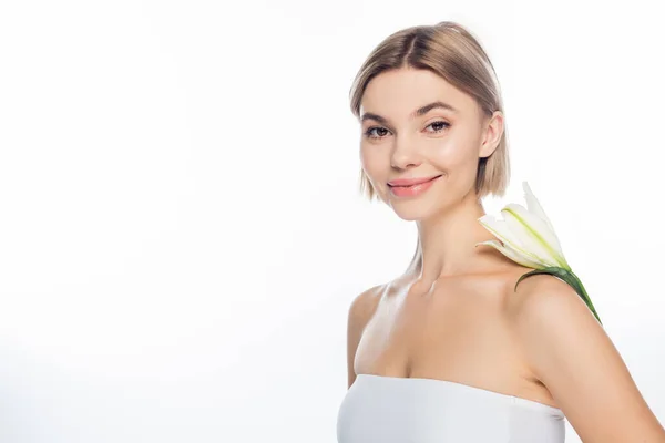 Joyeuse jeune femme avec fleur en fleurs sur épaule nue isolé sur blanc — Photo de stock