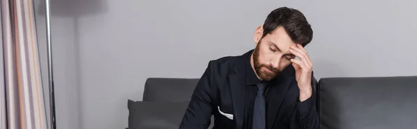 Homem de negócios cansado em terno sentado no sofá no quarto de hotel, banner — Fotografia de Stock