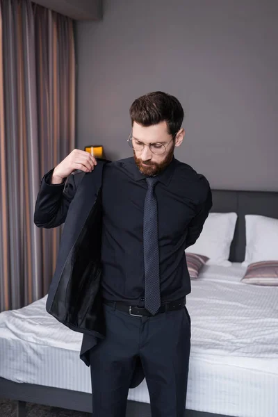 Bärtiger Mann mit Brille trägt Blazer im Hotelzimmer — Stockfoto