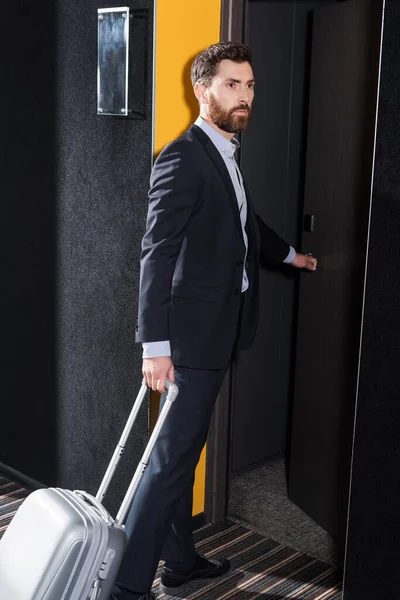 Homem barbudo com bagagem entrando quarto de hotel — Fotografia de Stock