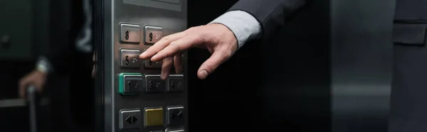 Cropped view of man pressing button in modern elevator, banner — Stock Photo