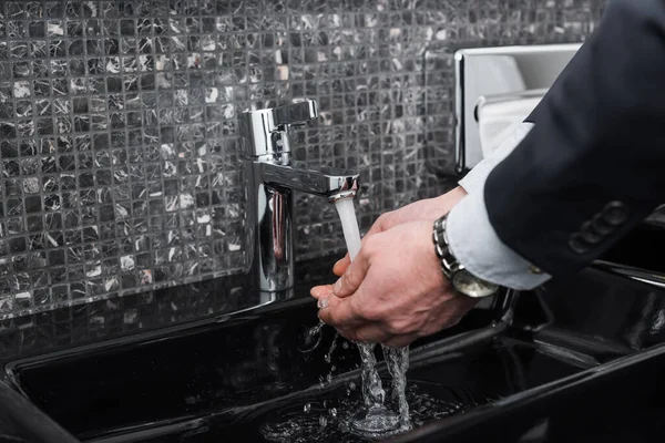 Abgeschnittene Ansicht eines Mannes, der sich im Hotelbadezimmer die Hände wäscht — Stockfoto