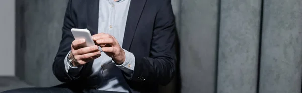 Cropped view of man in formal wear using smartphone in hotel lobby, banner — Stock Photo