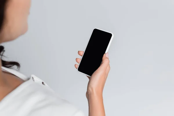 Vista ritagliata di donna che tiene il telefono cellulare con schermo vuoto isolato sul grigio — Foto stock