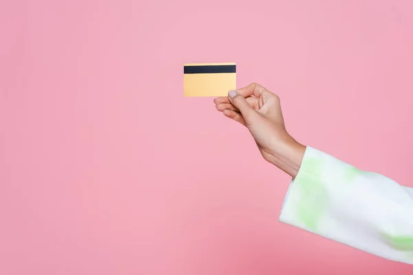 Vista recortada de la joven que sostiene la tarjeta de crédito aislado en rosa - foto de stock