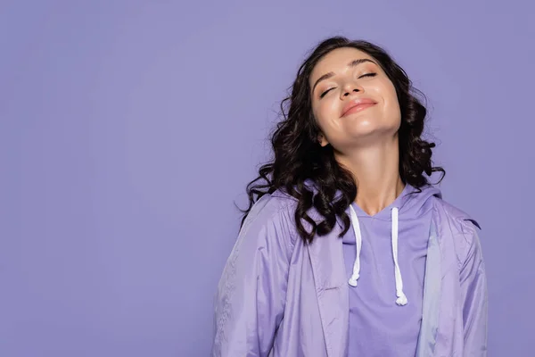 Jeune femme souriante aux yeux fermés isolé sur violet — Photo de stock