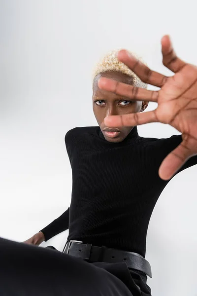 Блондинка афроамериканський молодий чоловік жестикулює ізольовано на сірому — стокове фото