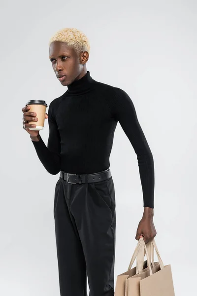 Blonde african american man standing with paper cup isolated on grey — Stock Photo