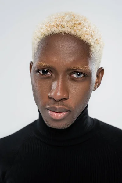 Portrait of blonde african american man with heterochromia isolated on grey — Stock Photo