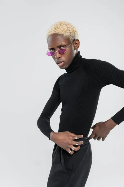 Blonde afrikanisch-amerikanische Mann mit Rollkragen und Sonnenbrille isoliert auf grau — Stockfoto