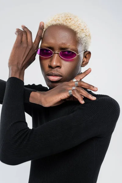 Blonde african american man in turtleneck and stylish sunglasses posing isolated on grey — Stock Photo