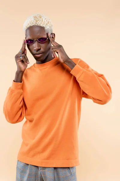 Young african american man in stylish sunglasses and sweatshirt isolated on beige — Stock Photo