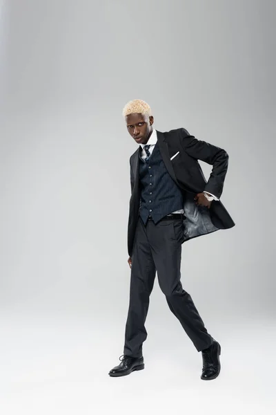 Comprimento total de homem americano africano elegante em desgaste formal posando em cinza — Fotografia de Stock