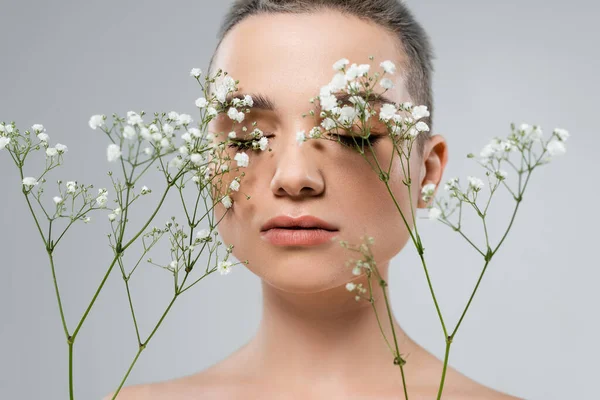 Retrato de mulher encantadora com pele perfeita perto de ramos de gypsophila isolado em cinza — Fotografia de Stock