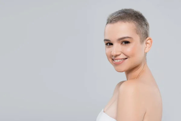 Young woman with perfect skin and natural makeup smiling at camera isolated on grey — Stock Photo
