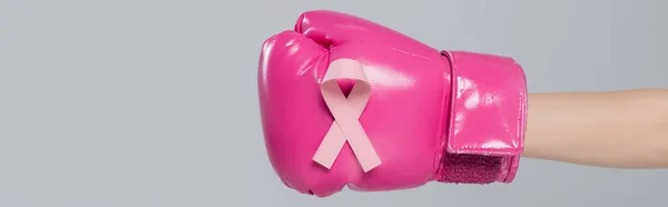 Partial view of woman in pink boxing glove with breast cancer awareness ribbon isolated on grey, banner — Stock Photo