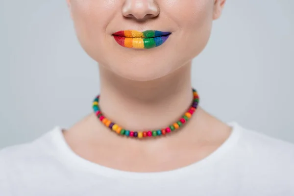 Cropped view of woman with lgbt colors necklace and lips isolated on grey — Stock Photo