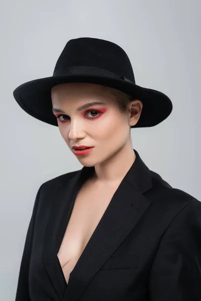 Elegante Frau mit hellem Make-up, die in die Kamera schaut, isoliert auf grau — Stockfoto