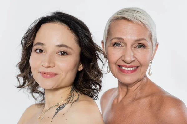 Smiling senior woman with naked shoulders near friend isolated on grey, feminism concept — Stock Photo