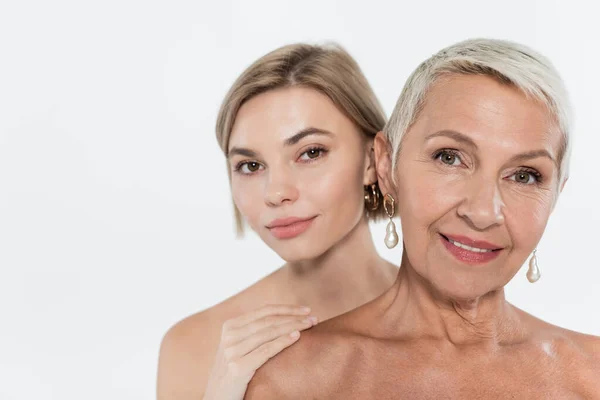 Junge Frau berührt nackte Schulter eines älteren Freundes isoliert auf grau — Stockfoto