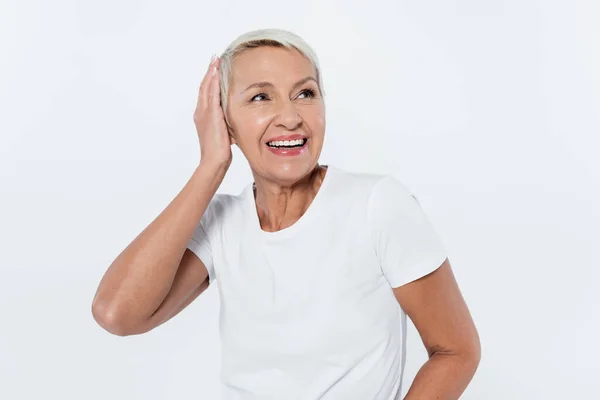 Glückliche Seniorin berührt Kopf isoliert auf grau — Stockfoto