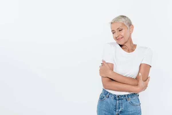 Lächelnde ältere Frau mit geschlossenen Augen posiert isoliert auf grau — Stockfoto