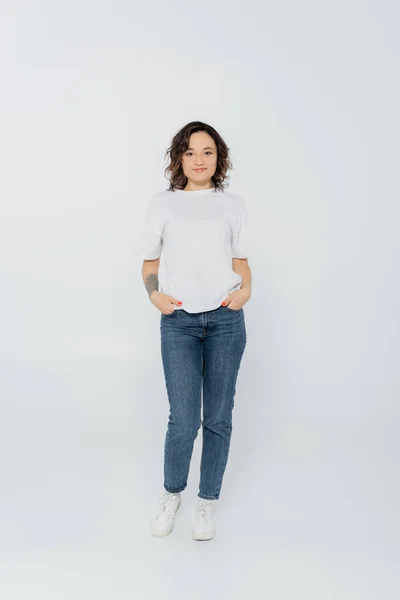 Full length of smiling woman posing on grey background — Stock Photo