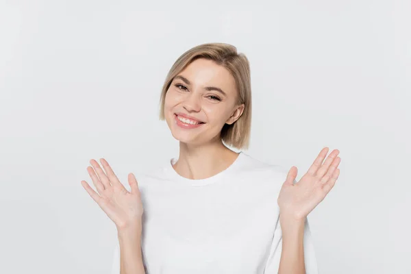 Happy blonde woman waving hands isolated on grey — Stock Photo