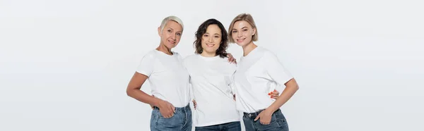 Junge Frau umarmt Freunde in weißen T-Shirts isoliert auf grauem Banner — Stockfoto