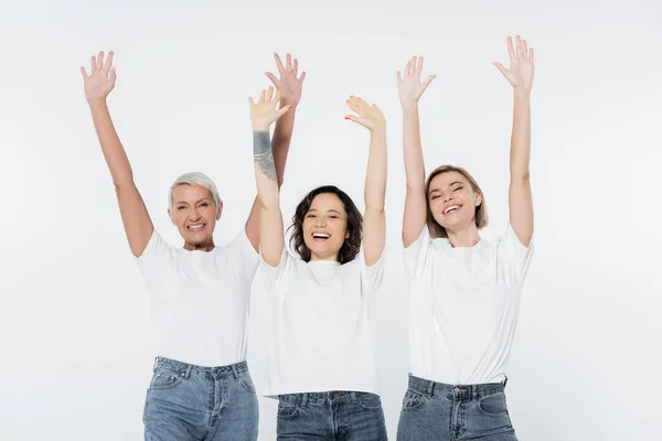 Веселі жінки махають руками і дивляться на камеру ізольовано на сірому — стокове фото