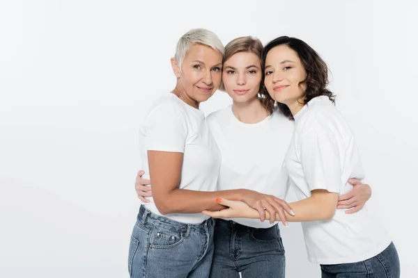 Donne in t-shirt bianche abbracciate isolate sul grigio, concetto di femminismo — Foto stock