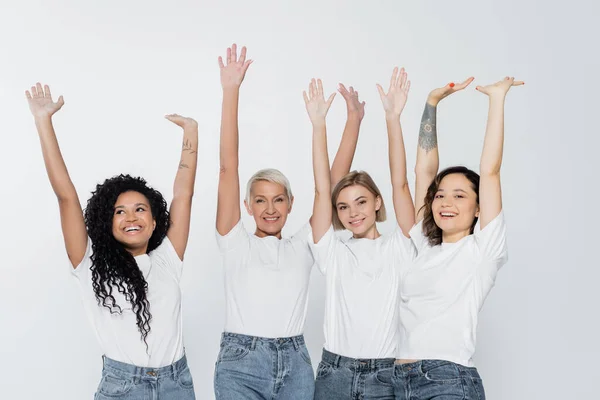 Mujeres sonrientes y multiétnicas saludando con las manos aisladas sobre el concepto de feminismo gris - foto de stock