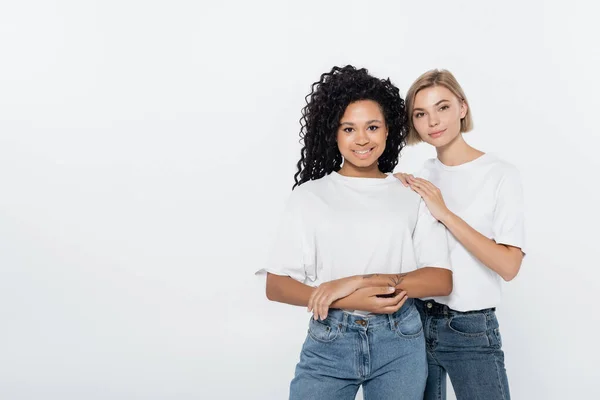 Jovem mulher abraçando sorridente amigo afro-americano isolado no conceito cinza, feminismo — Fotografia de Stock