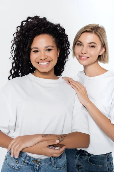 Glückliche Frau umarmt tätowierten afrikanisch-amerikanischen Freund isoliert auf grau — Stockfoto